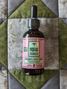 Glass bottle of Rogue Herbalist Women’s Daily Tonic Tincture 2oz with shatavari, dong quai, schisandra, raspberry leaf, damiana, and rose.